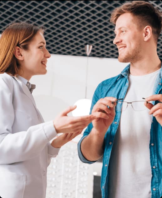 Homem segurando óculos de grau enquanto conversa com mulher